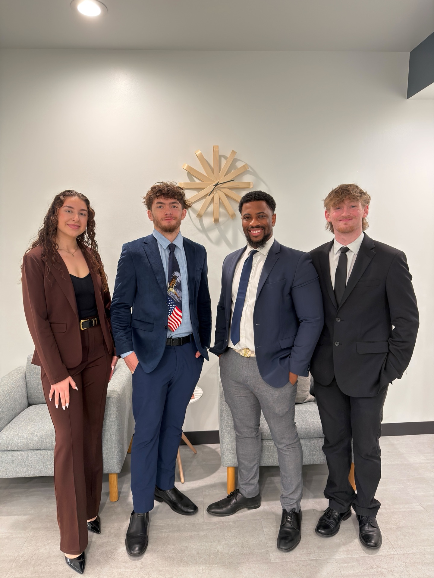 Essential Solutions Marketing team posing together in the Sacramento office — four professionals in business attire